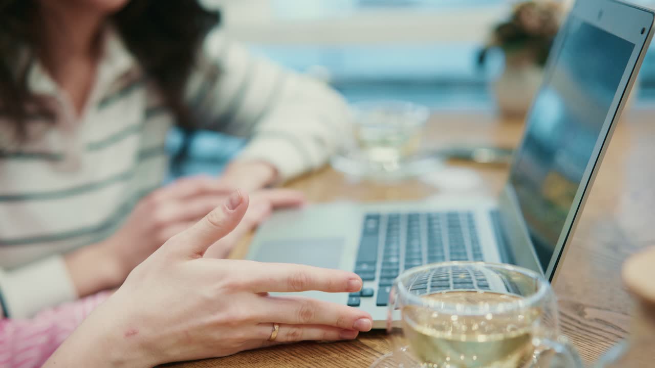 Close-up of Women's Hands Working on Laptop and Discussing