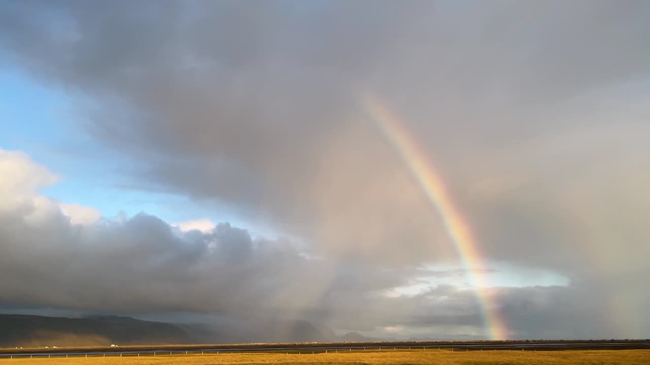 el arco iris sobre los cielos nublados de islandia, un toque de luz solar, un paisaje sereno