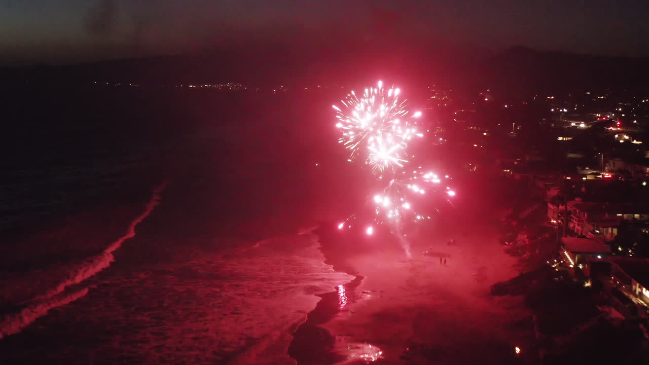 Night Fireworks Display Over Beach and Ocean
