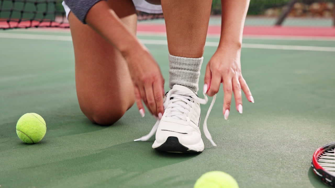 테니스 코트에서 신발을 는 여자