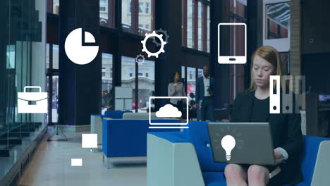 woman working on laptop in office lobby, colleagues holding coffee, displaying business icons