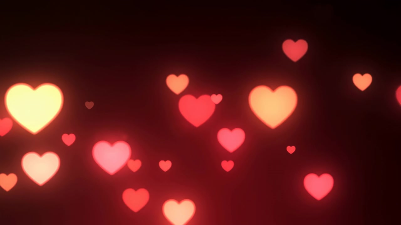 Cuori luminosi fluttuanti su sfondo scuro, luci bokeh soffuse rosse e rosa si muovono attraverso l'inquadratura creando un'atmosfera calda.