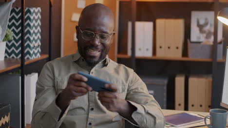 man playing mobile game in office