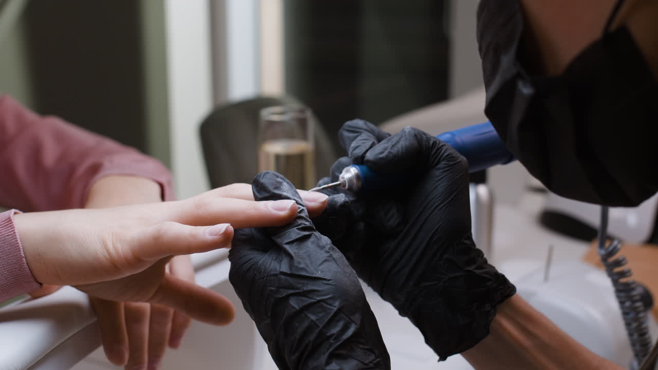 Woman getting a manicure with electric nail file