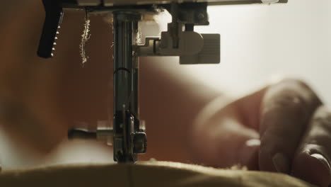 detalle de un primer plano de una máquina de coser. la aguja cosiendo tela