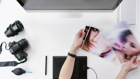 vista superior fotógrafo diseñador gráfico eligiendo imágenes de belleza trabajando en el escritorio desde arriba - dragón épico rojo
