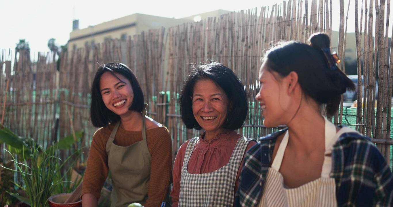 Glückliche asiatische Frauen lächeln in einem sonnigen Garten
