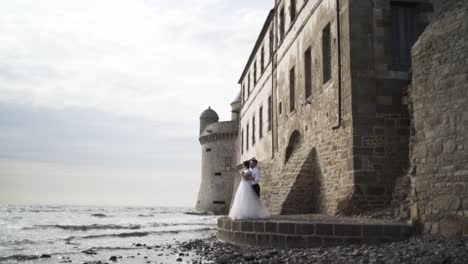 bride and groom by the seaside castle