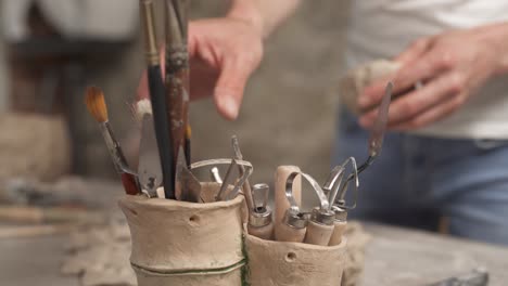 a close-up of male sculptors hands shaping clay for creating ceramic product in professional workshop