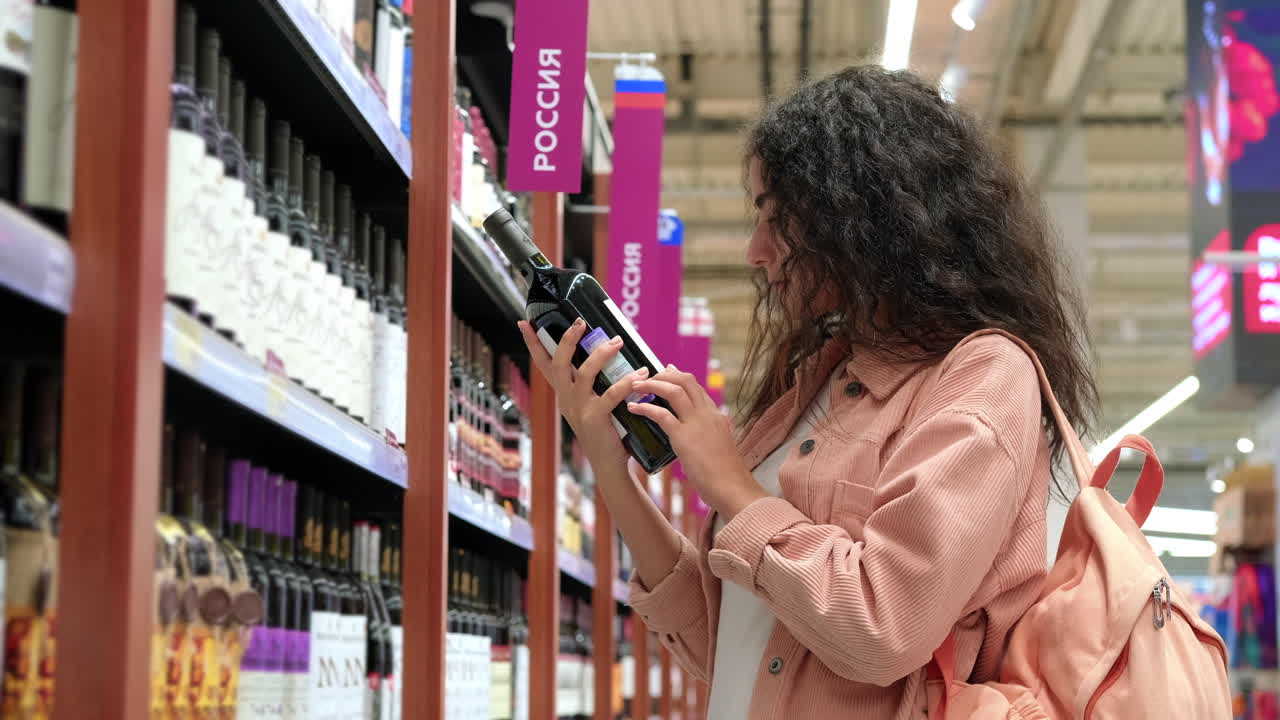 Donna che sceglie vino al supermercato