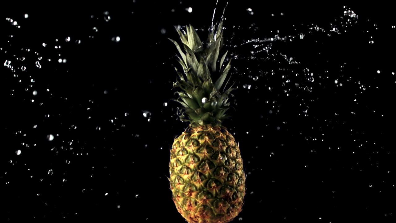 Water Splashes on a Ripe Pineapple in Slow Motion