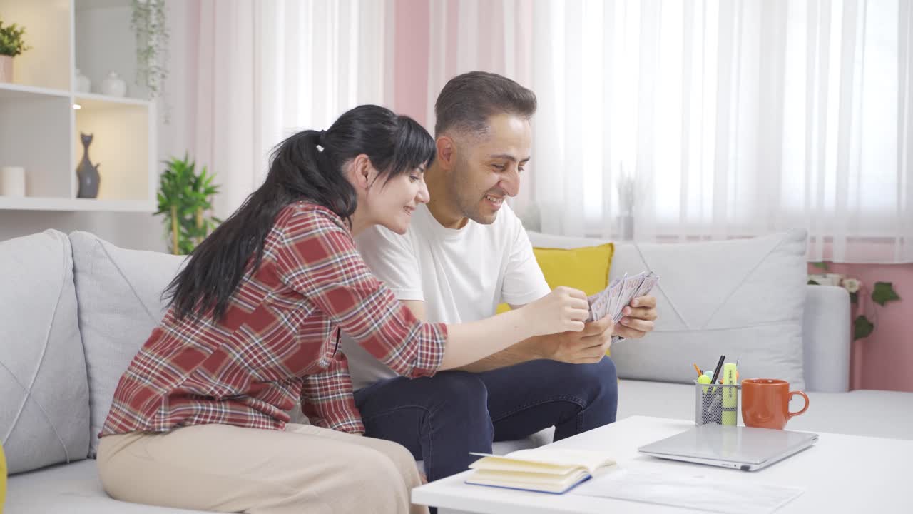 Pasangan itu bersukacita menghitung uang di rumah. Pasangan berpenghasilan tinggi