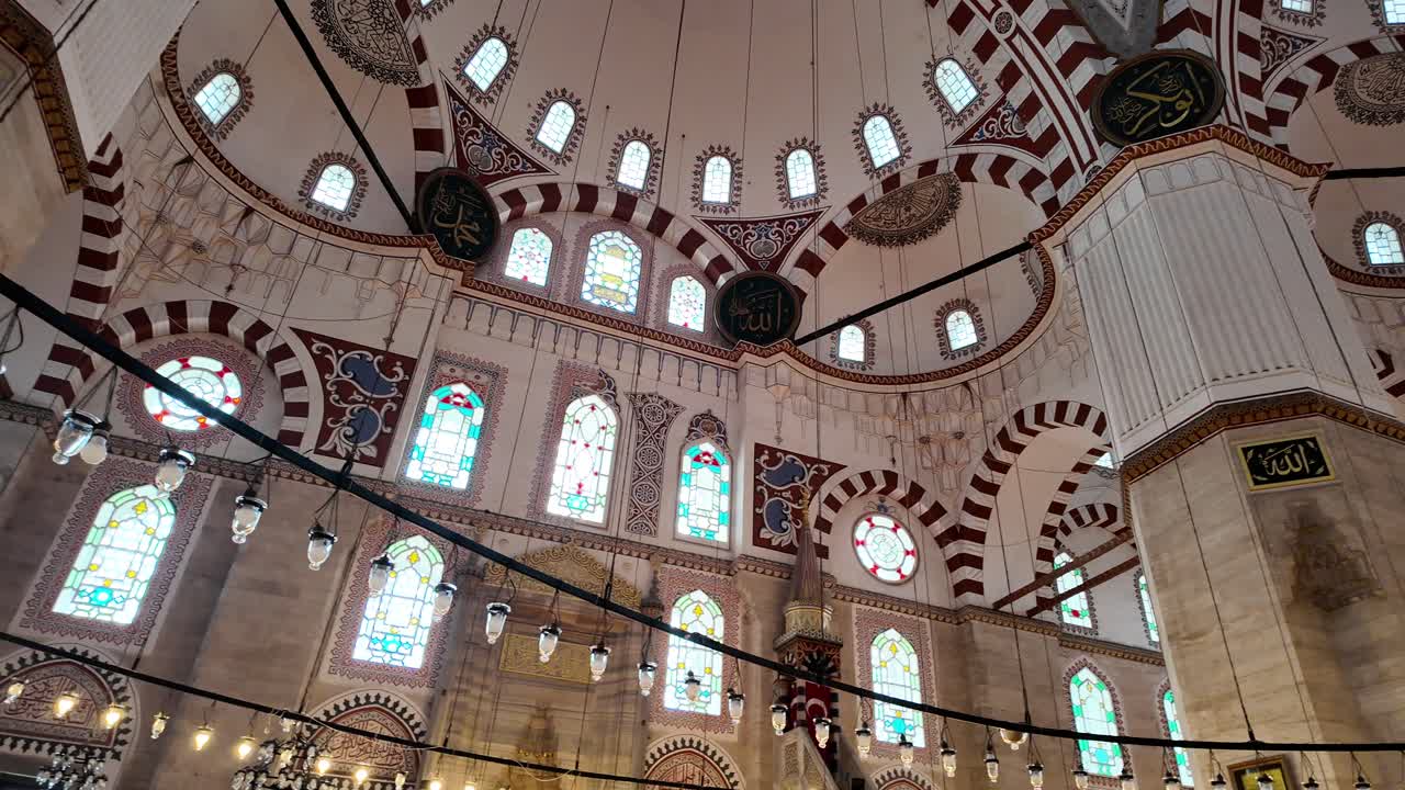 Ornate Interior of a Grand Mosque with Domed Ceiling, Stained Glass Windows, and Calligraphy