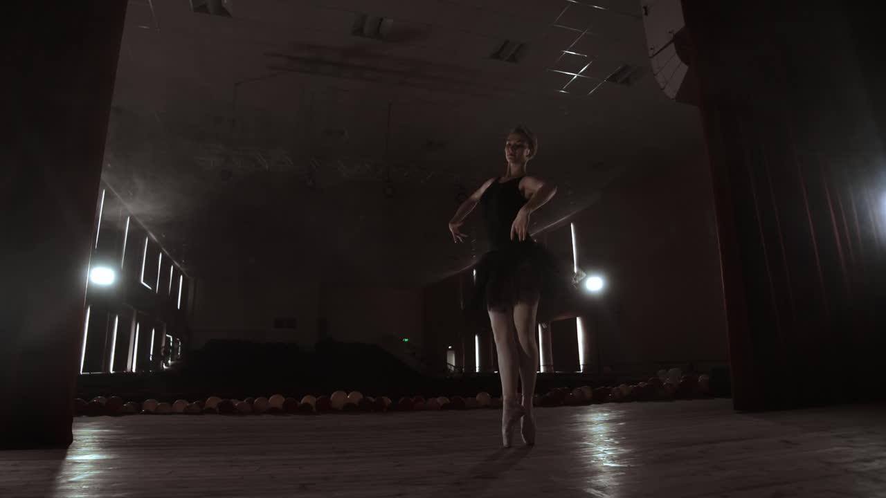 SLOW MOTION. unrecognizable beautiful ballerina performing on dark smoke stage. Blonde woman with hair in black. Ballet dress dancing with hands