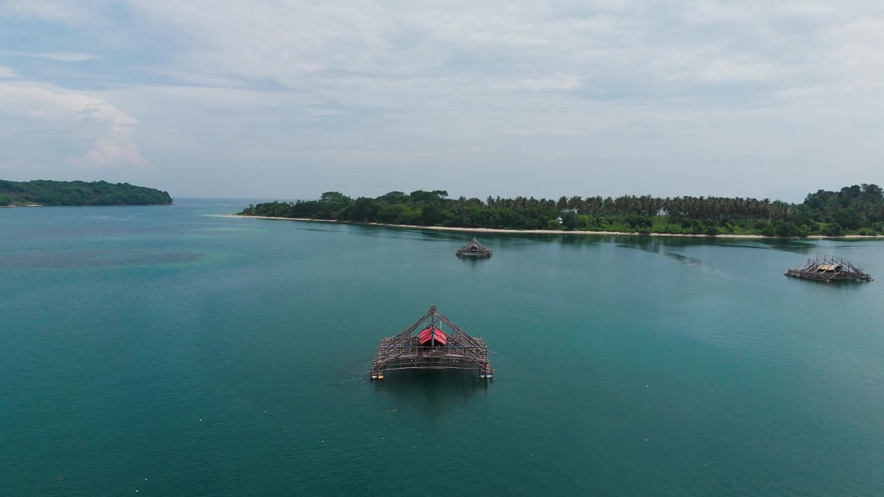 Endonezya'daki Gili Kedis yakınlarındaki Lombok Boğazı'nda yüzen geleneksel ahşap balıkçı platformunun havadan görünümü, izole yapıyı ve ekipmanlarını yukarıdan gösteriyor