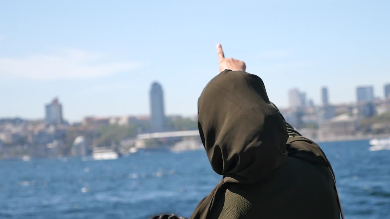 Woman pointing to Istanbul city from a ferry