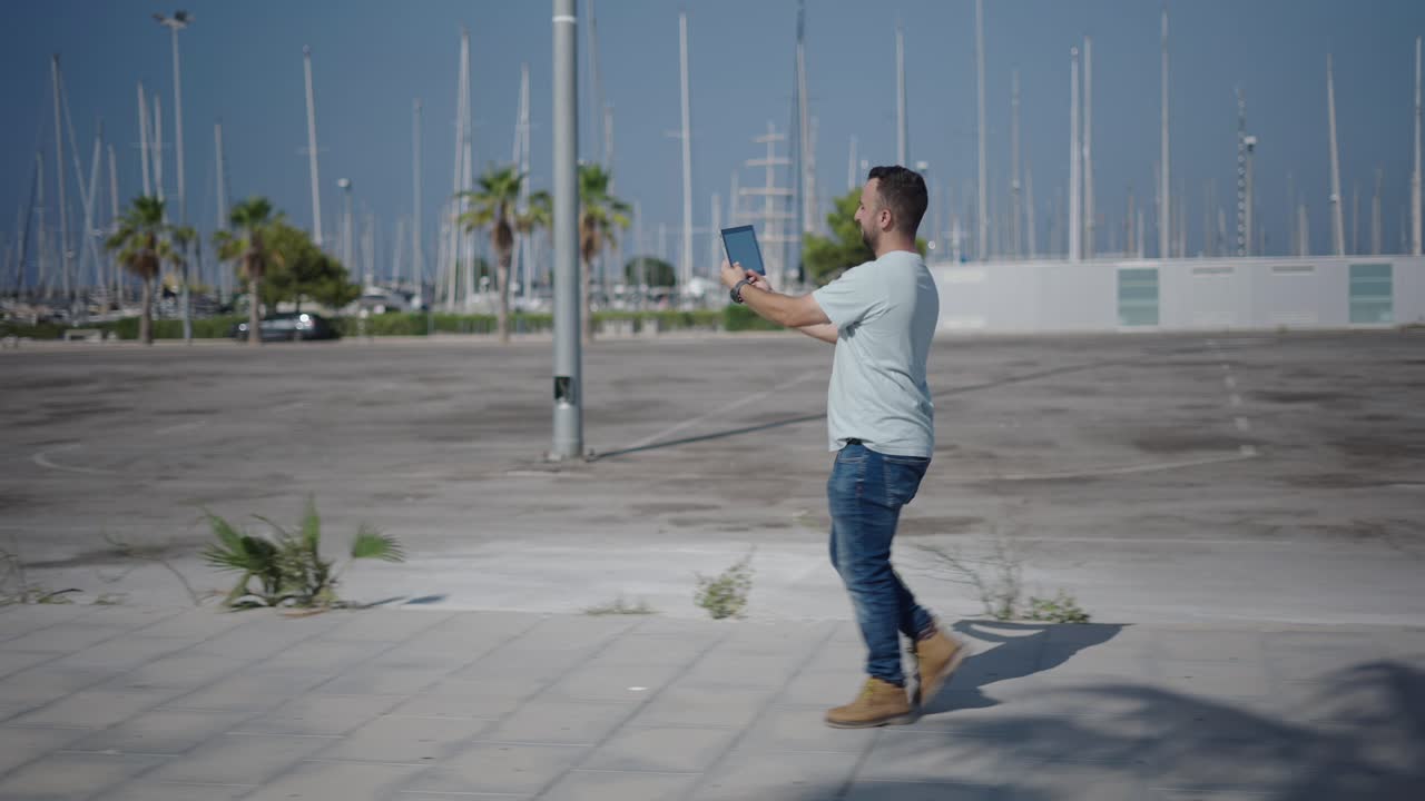 Man Walking and Using a Tablet Outside