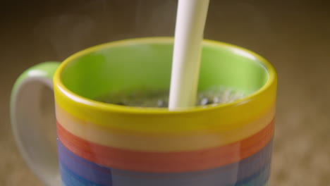 150fps slow motion frothy oat milk is added to a colourful mug