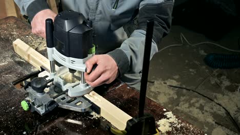 close-up of a carpenter's hand working with an manual electric cutter in a home workshop.