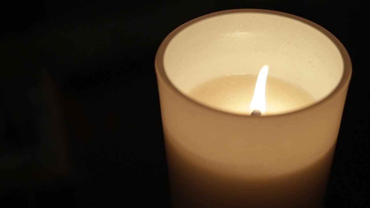 Luce di candela natalizia bianca che brucia.