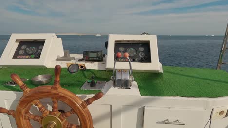 steering wheel and navigation compass on a yacht background of red sea