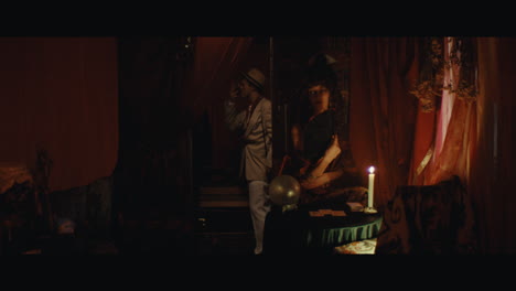 A man in hat checks the inside of the gypsy circus cart