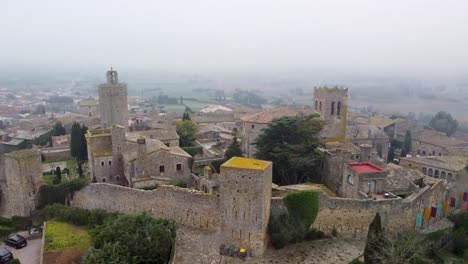 Mystical-Aerial-View-of-a-Fog-Enshrouded-Castle-in-Catalonia,-Northern-Spain