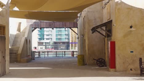 Old-Dubai-Of-Buildings-And-Traditional-Arabian-Streets-With-Cityscape-In-Background-At-Historical-Al-Fahidi-Neighborhood,-UAE