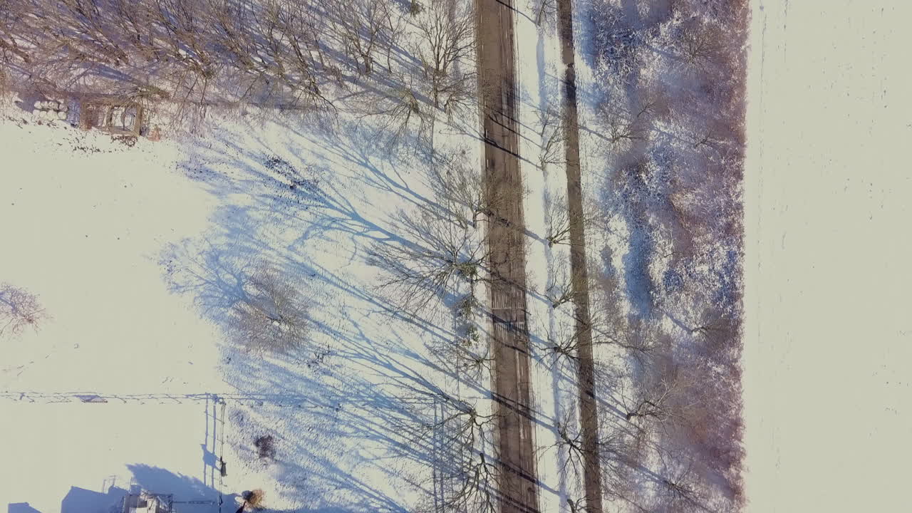 Aerial drone shot of the top-down view of the snowy road in Europe