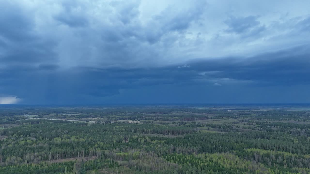 Green woodland and storm clouds above, time lapse view