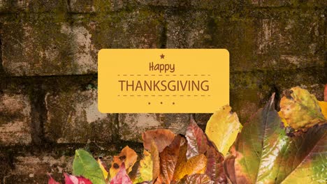 Animation-of-happy-thanksgiving-text-over-bricks-with-autumn-leaves