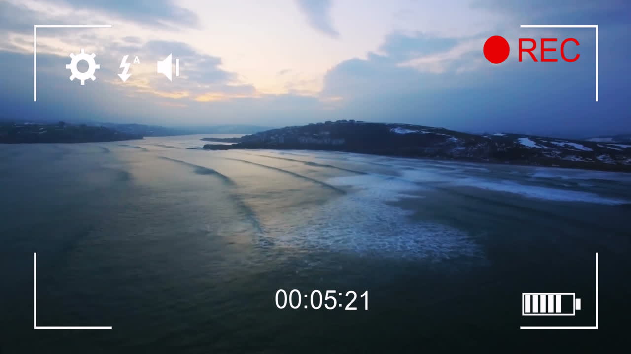 Camera interface animation over aerial view of serene coastal landscape at dusk