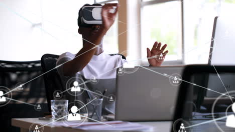 animation of network of connections with icons over african american businessman using vr headset