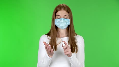 코로나 바이러스 확산을 막기 위해 카메라를 바라보고 손에 살균제를 적용하는 의료 보호 얼굴 마스크를 입은 어린 소녀의 초상화