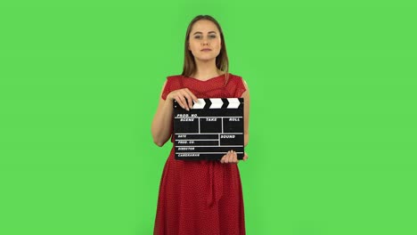 woman holding clapper board on green screen