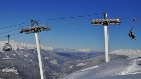 lapso de tiempo de un telesilla en los alpes franceses con un valle y un cielo azul en el fondo en invierno