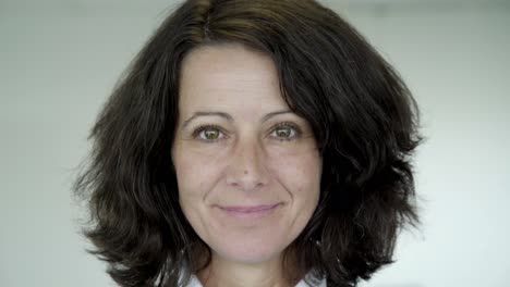 happy middle aged woman with green eyes looking at camera