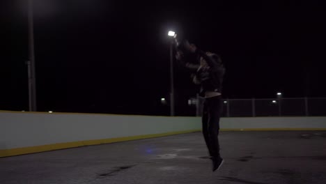 Teenage-girl-dribbles-ball-then-shoots-it-at-the-net-at-an-outdoor-court-with-lights-in-the-dark