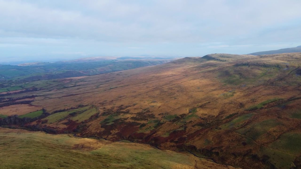 Fremadgående luftfoto af Brecon Beacons Bannau Brycheiniog Black Mountain-landskabet med grønne marker i baggrunden og bjergtop i Wales, Storbritannien. Vandring, Rejse, Droneoptagelser 4K.