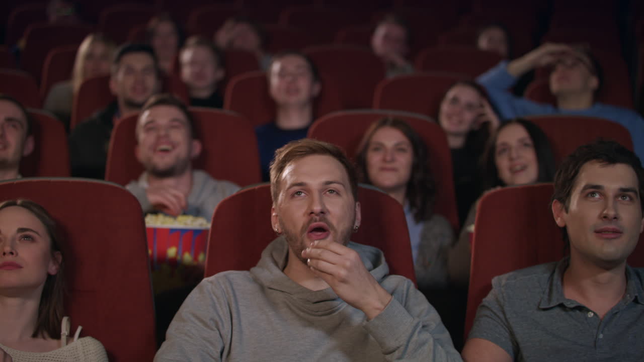 jóvenes viendo películas en el cine. gente de cine emoción