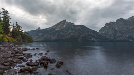 rocky shore of jenny lake with a view of teton mountain range in wyoming