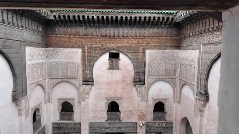 Window-view-of-authentic-Moroccan-riad-indoor-garden,-roof-with-green-tiles