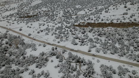 car and camper caravan driving along the snowy landscape of utah in winter