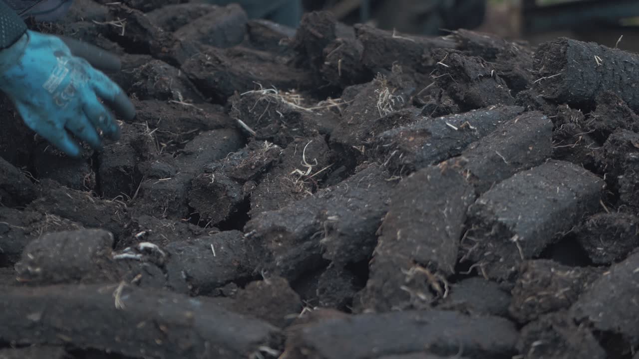 손으로 잔디 이탄을 모으는 슬로우 모션