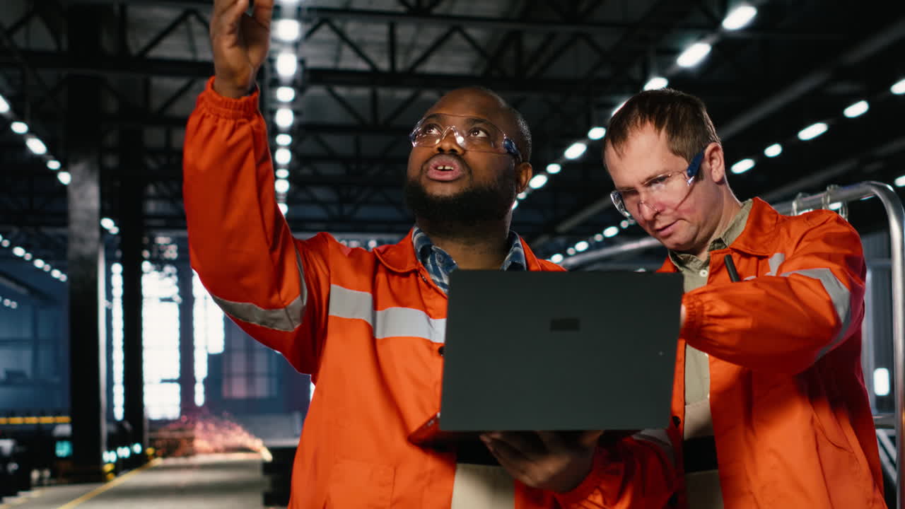 Diverse operators use laptop to coordinate production activity on factory floor