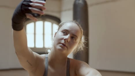 Close-up-shot-of-tired-after-workout-girl-taking-selfie-on-phone