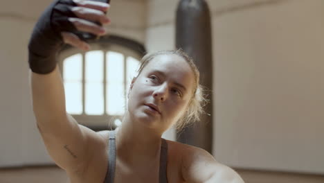 disparo en primer plano de una chica cansada después del entrenamiento tomando una selfie en el teléfono