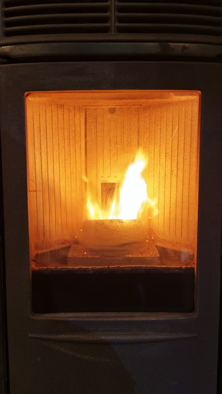 Vertical close up of bright fire inside pellet stove