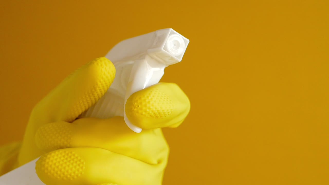 limpieza con botella de pulverización y guantes