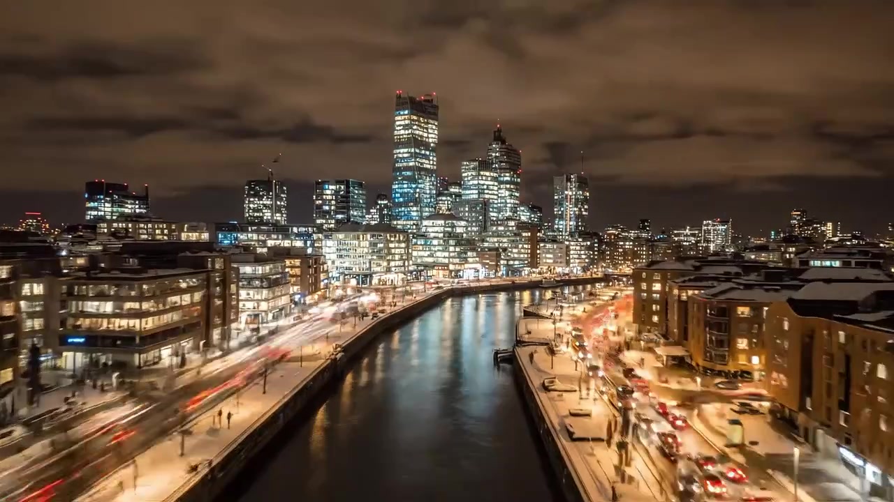 A Stunning Nighttime Cityscape with Snowy Streets, Illuminated Buildings, and Flowing Traffic Capturing the Vibrant Energy of Winter in an Urban Environment